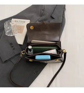 Detail view of the brown leather bag interior with multiple compartments and gold hardware