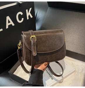 Detailed view of vintage dark brown crossbody bag in a premium black gift box set