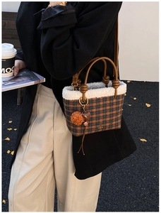 Détail du sac à main à carreaux avec bordure en fourrure et breloque cœur en automne