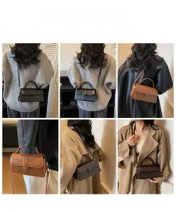 Modella che indossa la borsa a tracolla vintage in nero, marrone e caffè con cuciture a V
