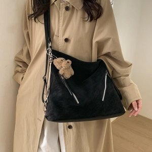 Detail of black Harajuku canvas tote with metal zippers and brown plush bear charm