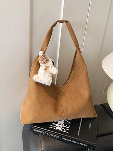 Brown faux suede tote bag with cute plush pendant and spacious interior for daily commute