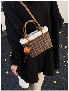 Détail du sac cabas à carreaux en peluche avec bordure en fourrure porté par un mannequin