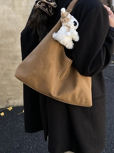 Brown suede hobo tote bag with white stitching and cute plush rabbit charm accessory