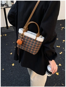 Détail du sac à main vintage à carreaux avec bordure en fourrure et pompon orange vif