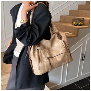 Détail du sac fourre-tout kaki montrant la matière texturée vintage et la poche zippée