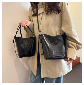 Set of black bucket bags with pleated texture and GOODS BAG embossing on model
