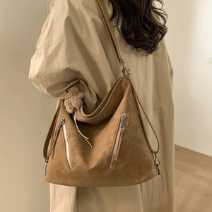 Detail of camel brown large capacity shoulder bag with fuzzy bear charm and zippers
