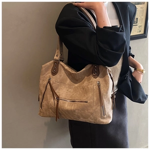 Détails du sac cabas camel avec fermetures éclair métalliques, rivets et texture cuir rétro