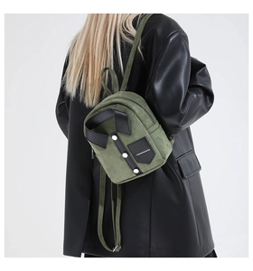 Detail of dark green suede backpack with shirt design and metallic white buttons