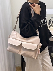 Minimalist beige nylon crossbody bag with dual utility pockets and adjustable strap