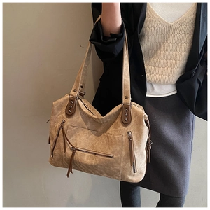 Gros plan du sac polochon vintage kaki avec fermetures éclair métalliques et détails en cuir