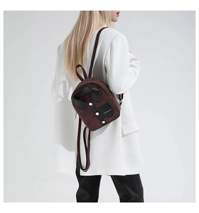Detail of dark brown mini backpack with lapel design and decorative silver buttons
