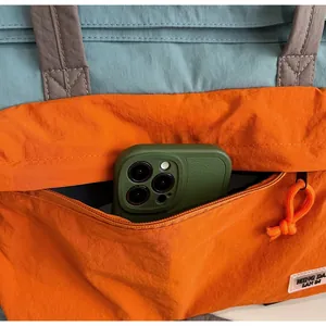 Dettaglio borsa da viaggio in nylon bicolore con tasca frontale a zip e grande capienza