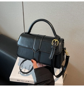 Macro di borsa in pelle nera con cuciture verticali e dettagli metallici dorati raffinati