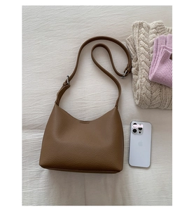 Detail shot of brown lychee grain leather hobo bag with adjustable strap and silver buckle