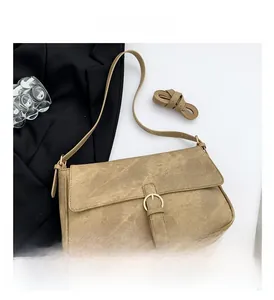 Détail d'un sac à rabat rétro kaki avec boucle métallique et bandoulière en cuir
