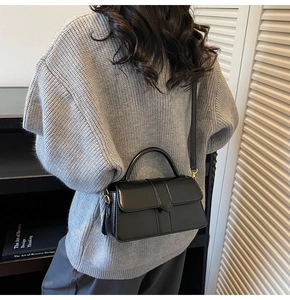 Vista posteriore di una modella con la borsa a tracolla in pelle nera opaca con manico