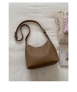 Close-up of brown lychee grain leather hobo bag with adjustable silver metal buckle strap
