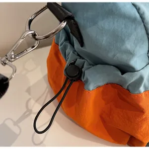 Dettaglio della borsa da viaggio in nylon blu e arancione con coulisse e gancio