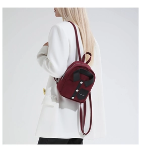 Detail view of burgundy suit-collar backpack with metallic buttons and fashion label