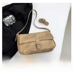 Détail du sac bandoulière rétro kaki avec boucle dorée et texture cuir vintage