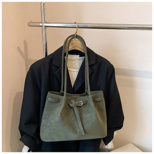 Olive green suede tote bag with decorative buckle shown styled on a shoulder