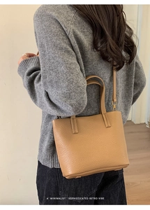 Back view of model wearing a minimalist light brown lychee grain leather tote bag