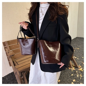 Detail of dark brown leather bucket bags with Forrest Bag lettering in autumn park