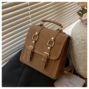 Macro detail of brown suede backpack with white contrast stitching and gold buckle