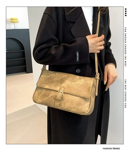 Sac bandoulière en similicuir marron avec boucle en métal porté par un mannequin