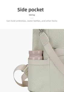 Close-up of side pocket on beige woven backpack holding a pink water bottle