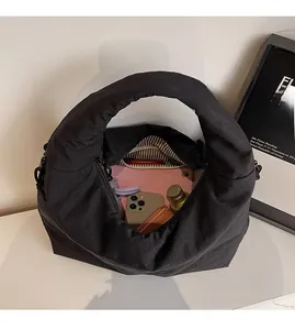 Spacious interior of black quilted tote bag holding a tablet, phone, and cosmetics
