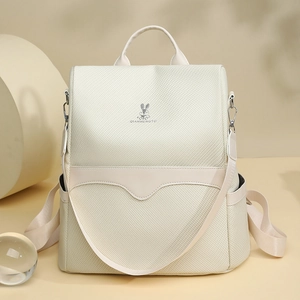 Detailed view of beige backpack fabric texture with cute rabbit logo and brand embroidery