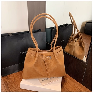 Detailed mirror view of large brown suede tote bag with decorative leather buckle