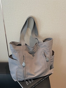 Spacious grey nylon tote bag with multiple zipper pockets and side compartments for women