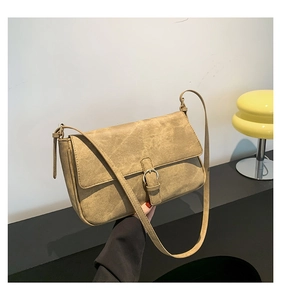 Détail d'un sac bandoulière rétro kaki avec texture mate et boucle métallique ronde