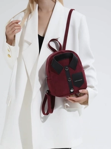 Burgundy mini backpack with creative shirt design held by a model in a white suit