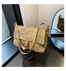 Gros plan d'un sac à bandoulière vintage kaki avec boucle métallique et texture vieillie