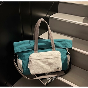 Dettaglio della borsa da viaggio verde acqua e bianca con texture e tracolle