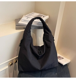 Close-up of minimalist black fabric tote bag with soft drawstring texture and large capacity