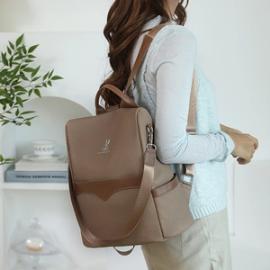 Brown textured fabric backpack with leather details and metal rabbit ornament