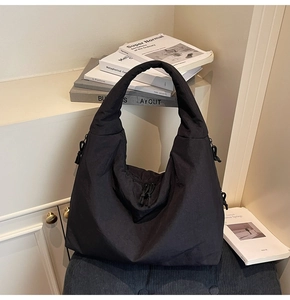 Detail of black large capacity tote bag featuring drawstring texture and soft padded fabric
