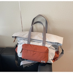 Dettaglio della borsa da viaggio in nylon con tasca arancione e tracolla regolabile