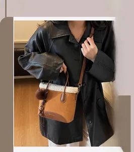 Détail du sac seau vintage caramel avec bordure en fausse fourrure blanche et pompon