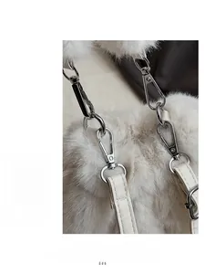 Détail d'un sac à main en fausse fourrure blanche avec mousqueton argenté et bandoulière