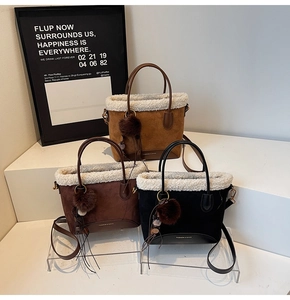 Détail de sacs seaux en daim avec bordure en fausse fourrure, pompons et bandoulières