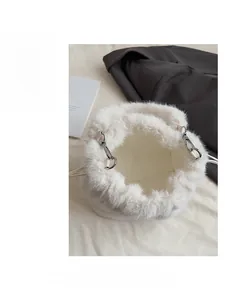 Détail d'un sac seau en fausse fourrure blanche avec cordon en cuir et boucles argentées