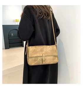 Gros plan du sac bandoulière vintage en cuir PU kaki avec boucle argentée sur mannequin