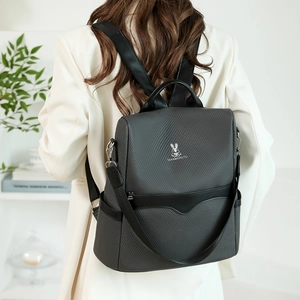 Close-up of charcoal gray backpack featuring the metallic logo and twill texture fabric